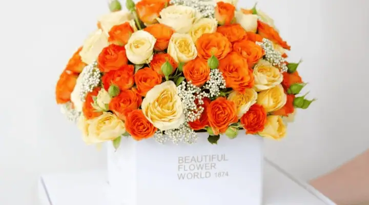 یک باکس گل با گل های نارنجی و زرد